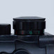 Close-up of black 4x32MDG rifle scope adjustment dial with red and green markings on matte finish body
